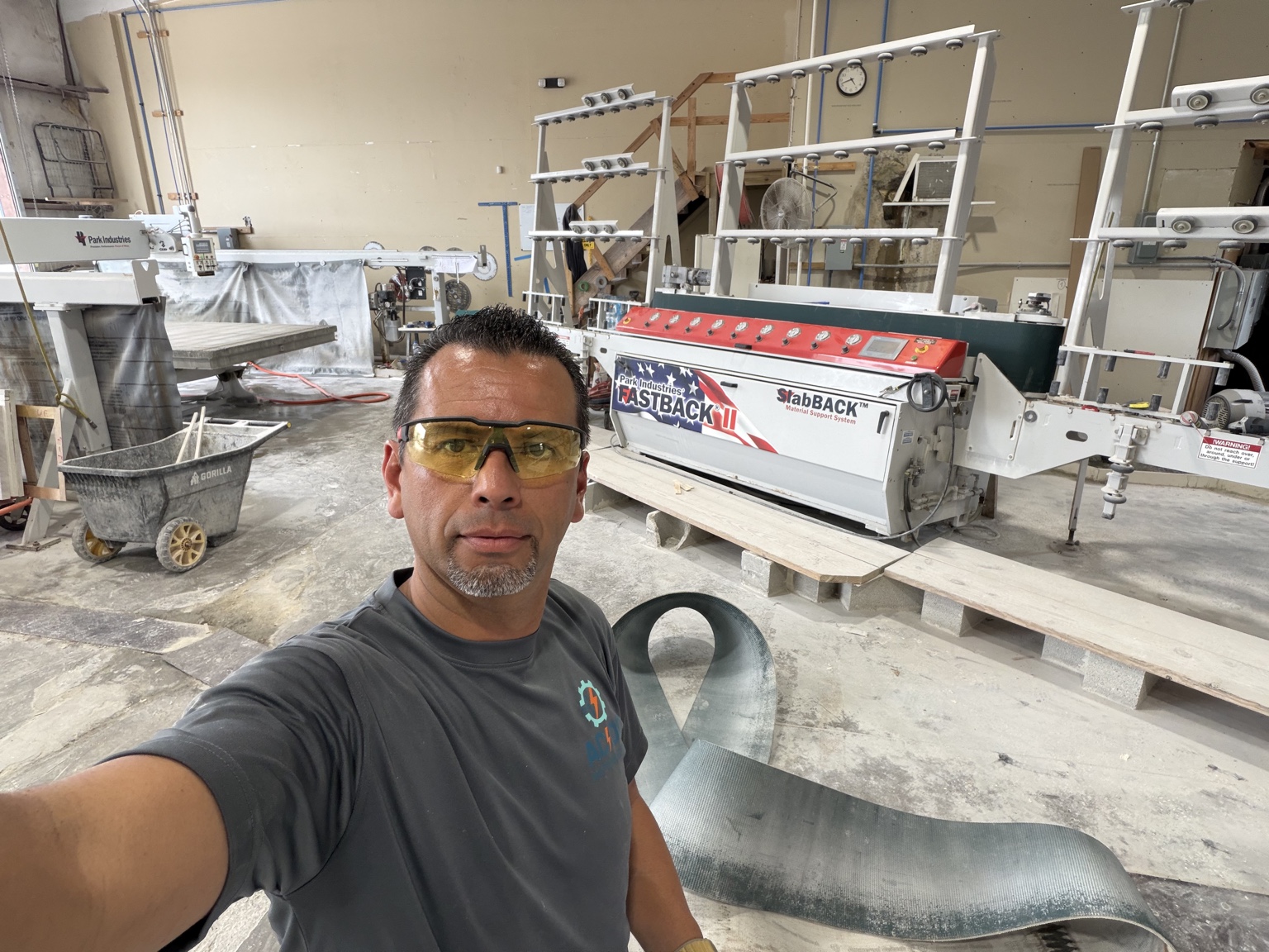 AC/DC Automation technician working beside stone-fabrication equipment